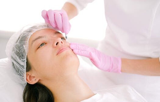 Woman receives cosmetic injection in clinical setting, enhancing beauty using modern techniques.